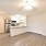 spacious living room with lighting fixture and ceiling fan with kitchen access