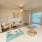 open kitchen counter looks into lighted living room with ceiling fan
